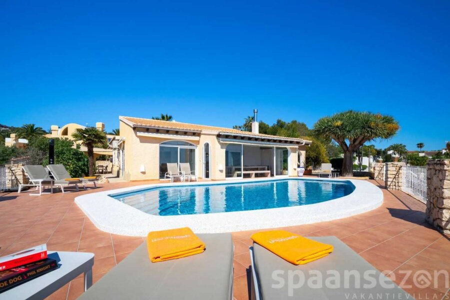 Zwembad villa Annamar in Moraira heeft een groot zwembad met rond een terras en zeezicht