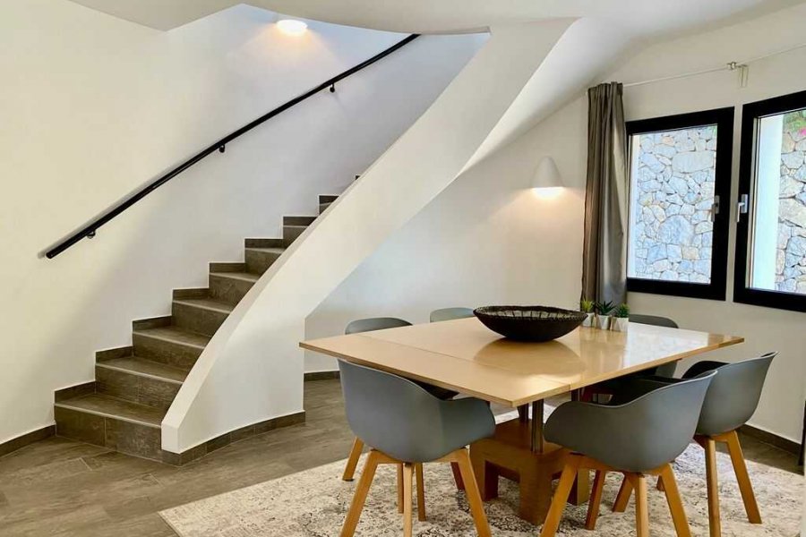 Luxe vakantievilla in Moraira met eetkamer die toegang geeft tot de halfopen keuken en woonkamer.