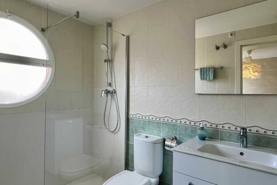 Moderne en-suite badkamer met inloopdouche, toilet en wastafel