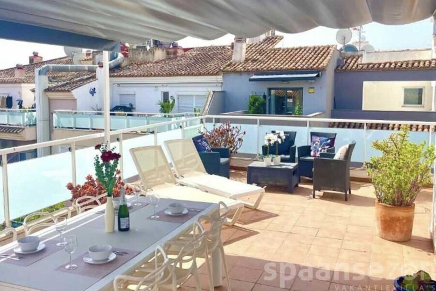 Het dakterras van Penthouse II heeft een grote eettafel staan